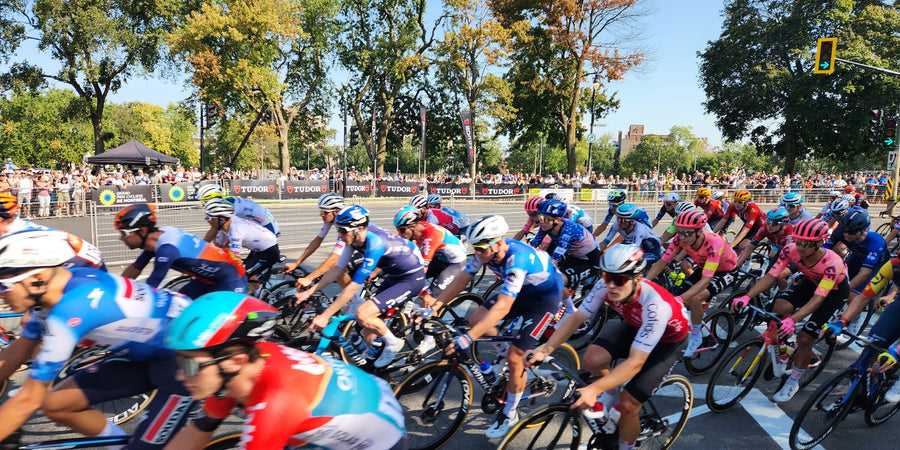 Peloton du Grand Prix Cycliste de Montréal 2024 sur l'avenue du Parc, devant la foule, sous les arbres aux couleurs d'automne