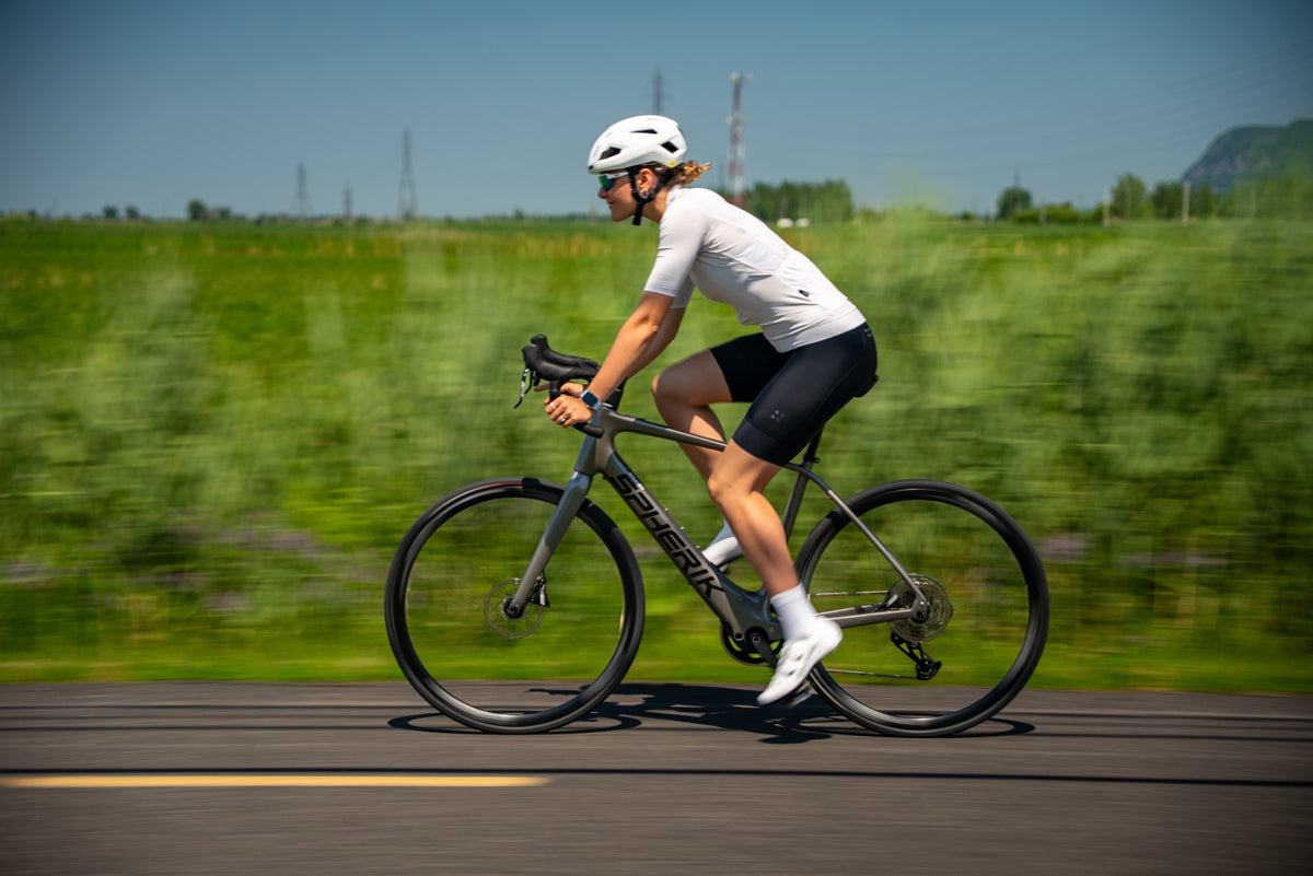 Cycliste roulant sur route avec un Spherik E-SRD gris en pleine campagne